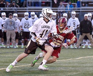 Attackman Dan Taylor, '15, dodges past a Denver defenseman and works to set up the offense for Lehigh on Tuesday, March 17, 2015. The Hawks had a 3-0 lead after the first quarter, but lost with a final score of 10-4. (Liz Cornell/B&W photo)