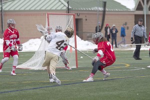 Senior attackman Patrick Corbett shoots past sophomore long stick midfielder Henry Lee of Boston University. The Mountain Hawks finished the season with an overall record of 7-9. (Liz Cornell/B&W photo)